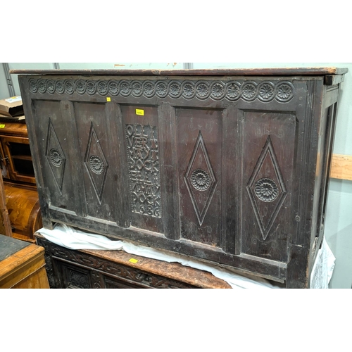 1070 - A late 17th/early 18th century framed and panelled oak coffer with plank top, carved frieze and 4 pa... 