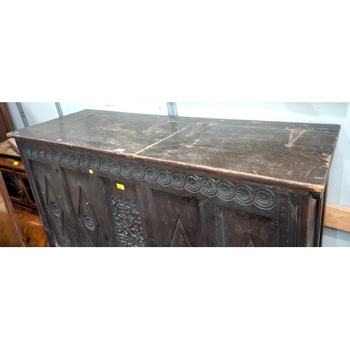 1070 - A late 17th/early 18th century framed and panelled oak coffer with plank top, carved frieze and 4 pa... 