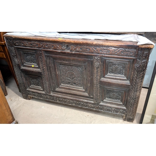 1071 - An extensively carved oak coffer with plank top.