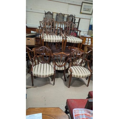 1078 - A set of ten repro mahogany dining chairs with with carved shield-shaped backs, green Regency stripe... 