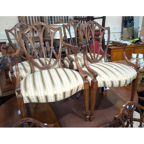 1078 - A set of ten repro mahogany dining chairs with with carved shield-shaped backs, green Regency stripe... 