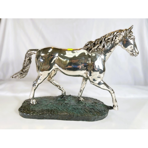 899 - A silvered metal sculpture of a horse on naturalistic bronzed base by 'D'Argenti', length 47cms.