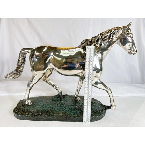 899 - A silvered metal sculpture of a horse on naturalistic bronzed base by 'D'Argenti', length 47cms.