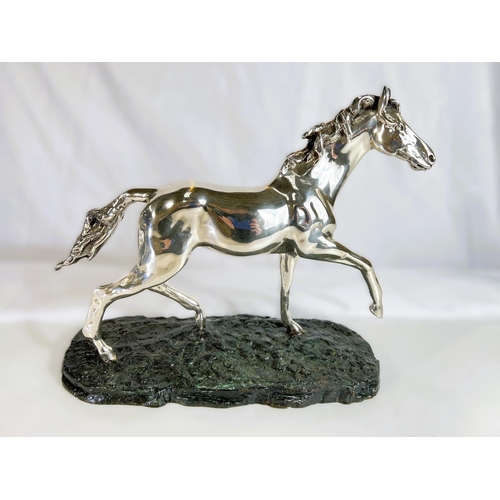 900 - A silvered metal sculpture of a horse on naturalistic bronzed base by 'D'Argenti', length 38cms.