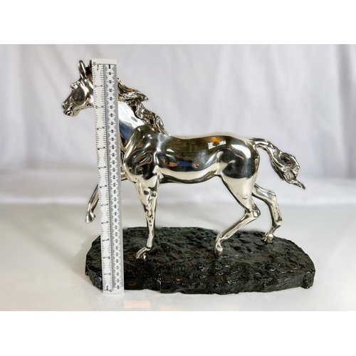 900 - A silvered metal sculpture of a horse on naturalistic bronzed base by 'D'Argenti', length 38cms.