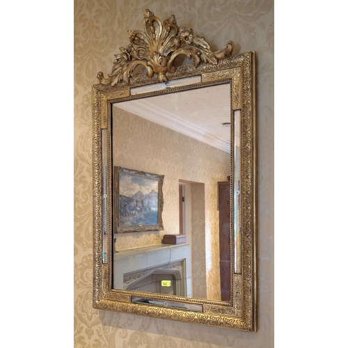 922 - A Venetian style gilt framed wall mirror with floral finial above, 120 x 73 cm.