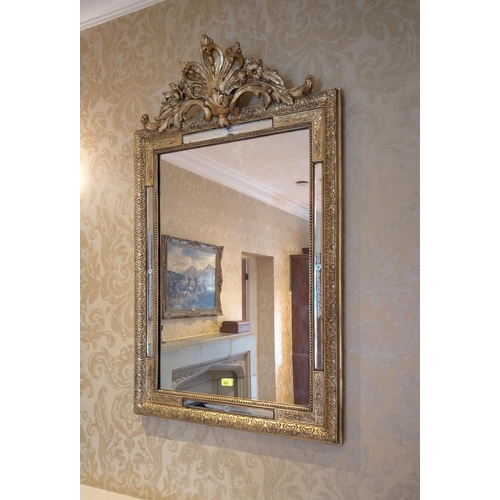 922 - A Venetian style gilt framed wall mirror with floral finial above, 120 x 73 cm.