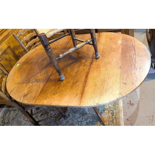 937 - A circular extending distressed oak extending dining table on central column and four splay feet, ex... 