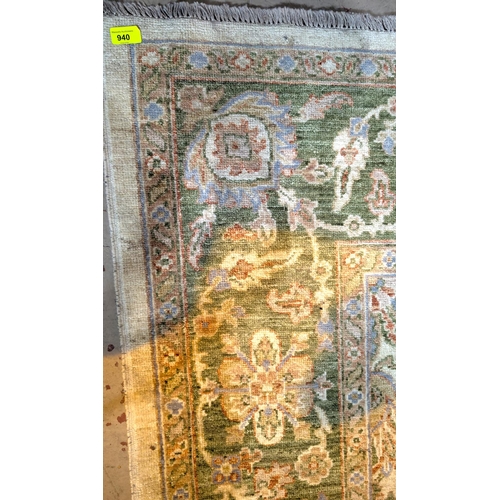 940 - A modern hand knotted green ground Persian rug, 277 x 187cm.