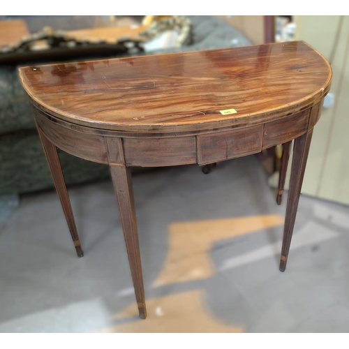 945 - A 19th century demi lune mahogany fold over tea table with satinwood cross banding and square taperi... 