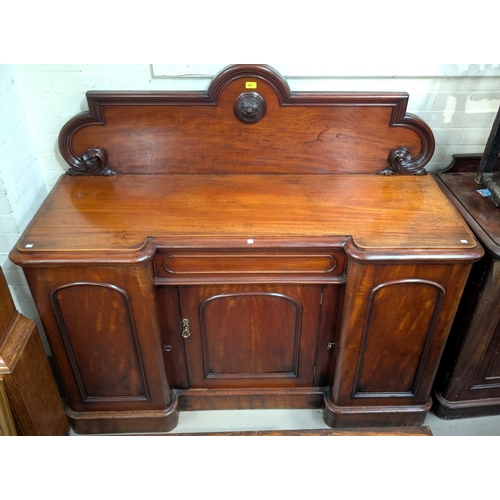 961 - A 19th century mahogany breakfront sideboard with carved and upright back, 3 panel doors and single ... 