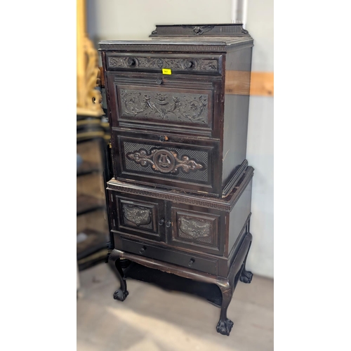 967 - An unusual chest on stand with carved doors and drawers with instrument and cornucopias etc with two... 