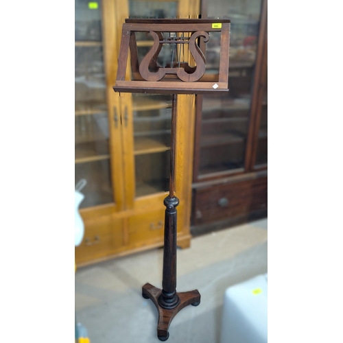 995 - A late 19th century rosewood duet music stand, rise and fall on tripod base.