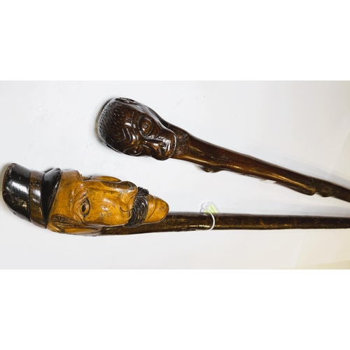 111 - An early 20th Century continental stick with carved head finial, 109cm, and another with ape finial,... 