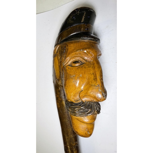 111 - An early 20th Century continental stick with carved head finial, 109cm, and another with ape finial,... 