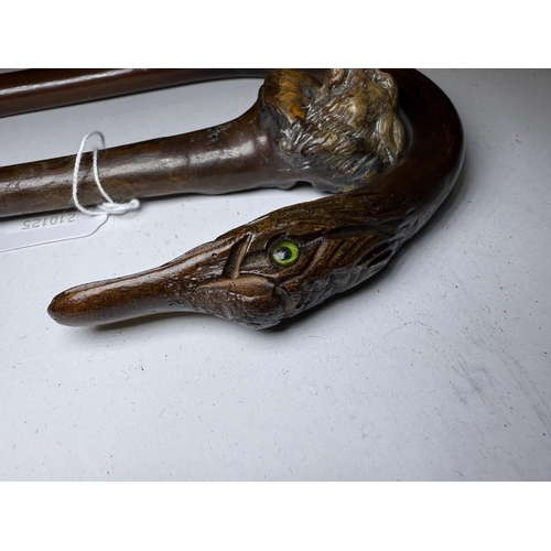 164 - An early 20th Century walking cane with carved dog's head finial, 90 cm, and two others similar (3).