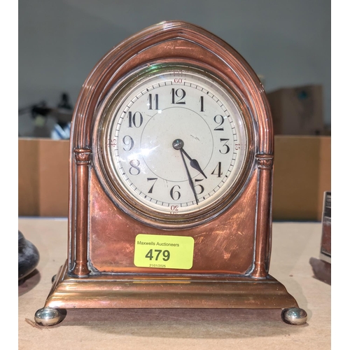 479 - A French copper mantel clock with enamel dial.