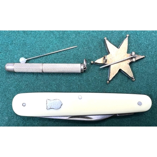 718 - A hallmarked silver retractable tooth pick with engine turned decoration; a star brooch; a white met... 