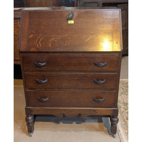 953 - A 1930's oak fall front bureau with three drawers.