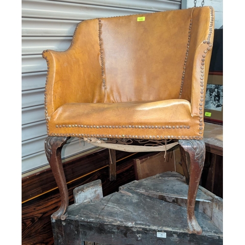 1072 - A tub chair in studded tan leather effect; a Queen Anne style armchair.