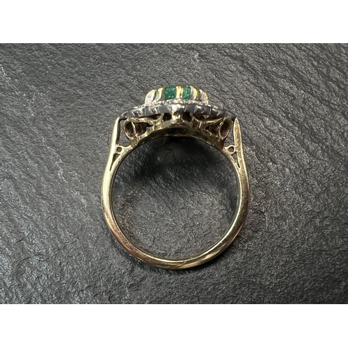 755 - An 18ct hallmarked gold diamond and emerald dress ring, the central emerald square cut and surrounde... 