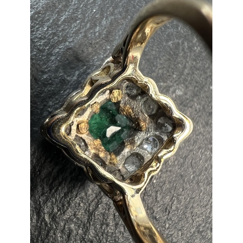 755 - An 18ct hallmarked gold diamond and emerald dress ring, the central emerald square cut and surrounde... 