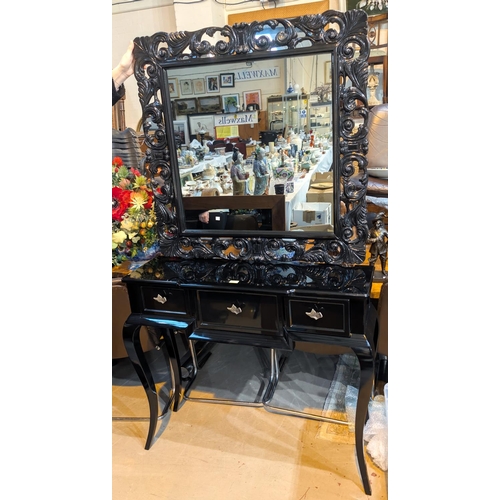 919 - A modern design black table with sculpted handles and a black framed mirror.