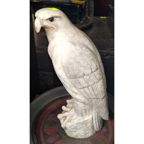 426 - An early 20th century alabaster carving of an eagle perched with glass eyes, ht. 42cm