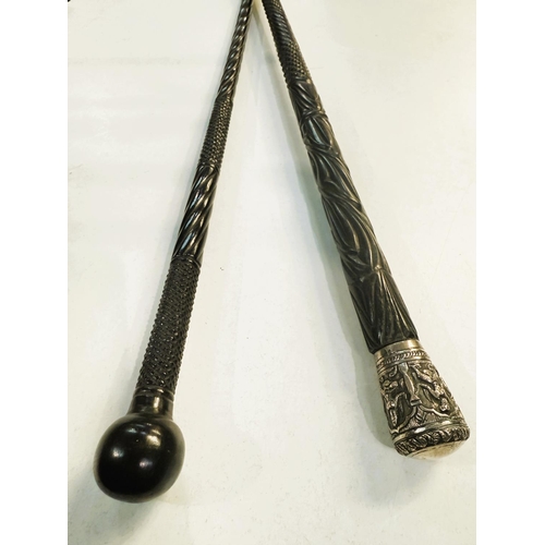 23 - A 19th Century carved Indian ebony walking stick with repousse work silver finial, 87cms, and anothe... 