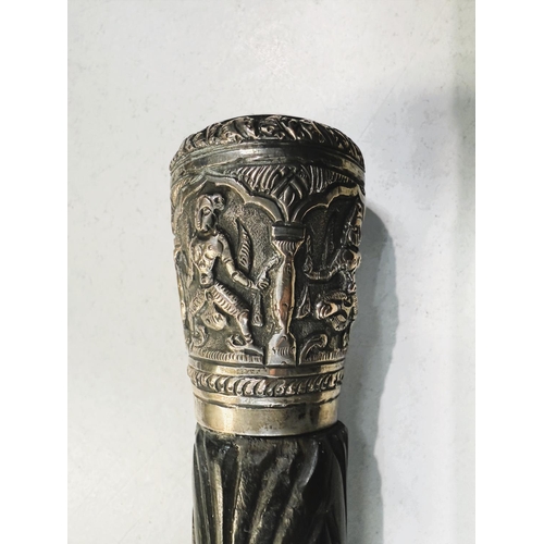 23 - A 19th Century carved Indian ebony walking stick with repousse work silver finial, 87cms, and anothe... 