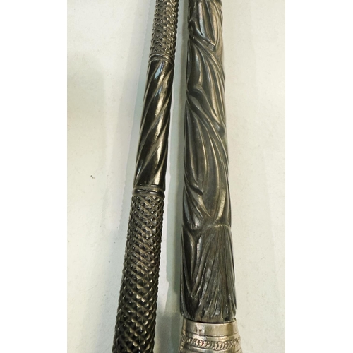 23 - A 19th Century carved Indian ebony walking stick with repousse work silver finial, 87cms, and anothe... 