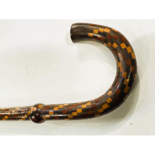 158 - An early 20th Century walking stick with coverall spiral geometric inlaid decoration, 80cm.