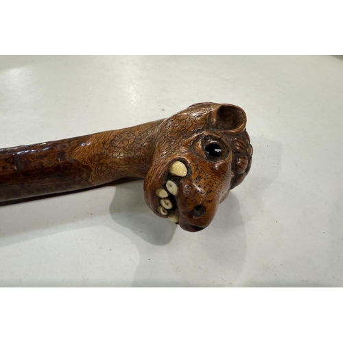 177 - A vintage rustic walking stick with carved head finial of a snaggle-toothed monster, 90cm.