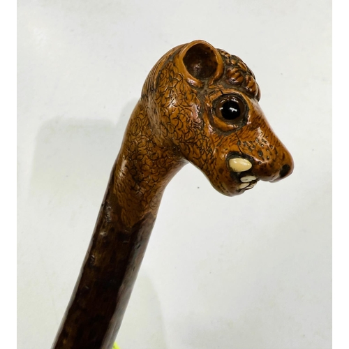 177 - A vintage rustic walking stick with carved head finial of a snaggle-toothed monster, 90cm.