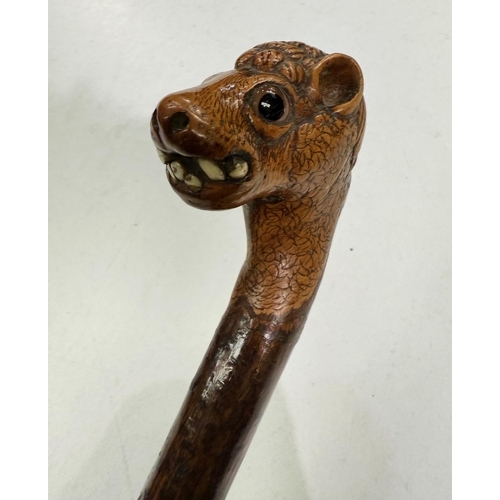 177 - A vintage rustic walking stick with carved head finial of a snaggle-toothed monster, 90cm.