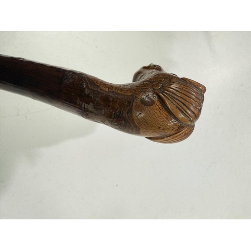 177 - A vintage rustic walking stick with carved head finial of a snaggle-toothed monster, 90cm.