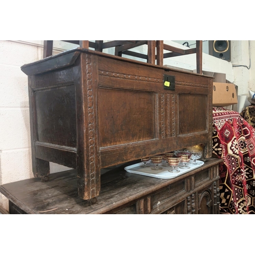 944 - An 18th century oak coffer chest with carved panels to the front.