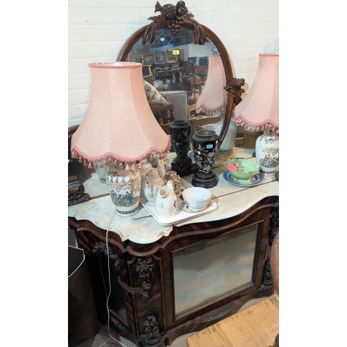 984B - A Victorian simulated zebra wood mirror back chiffonier, the raised oval back with carved fruit and ... 