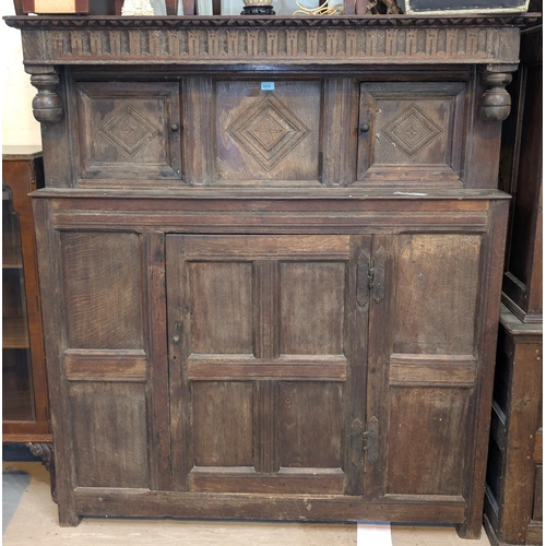 1010 - An 18th century oak court cupboard with twin diamond carved upper doors and framed and panelled sing... 