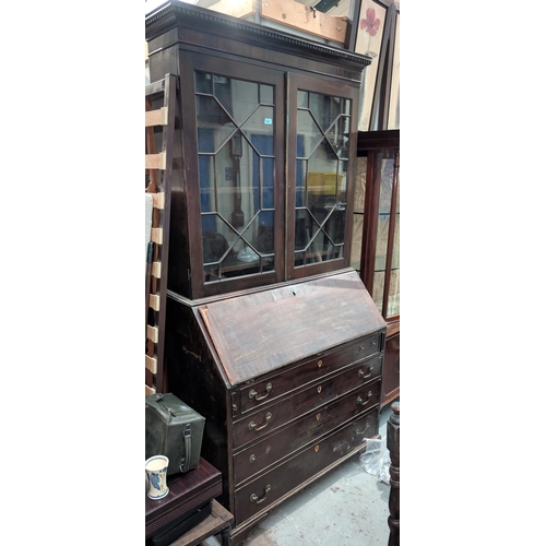 1009 - A Georgian mahogany bookcase with twin glazed doors to the upper section with fall front and inlaid ... 