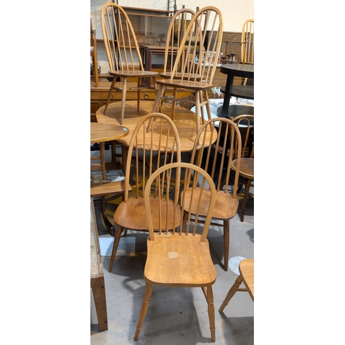 992 - Ercol, four high hoop back blonde chairs and four similar chairs.