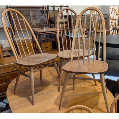 992 - Ercol, four high hoop back blonde chairs and four similar chairs.