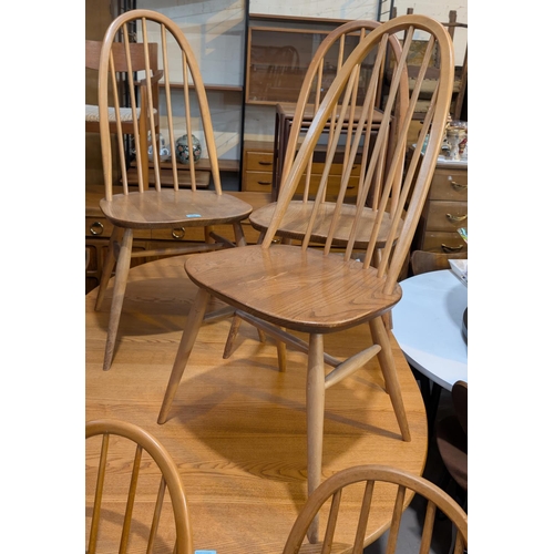 992 - Ercol, four high hoop back blonde chairs and four similar chairs.