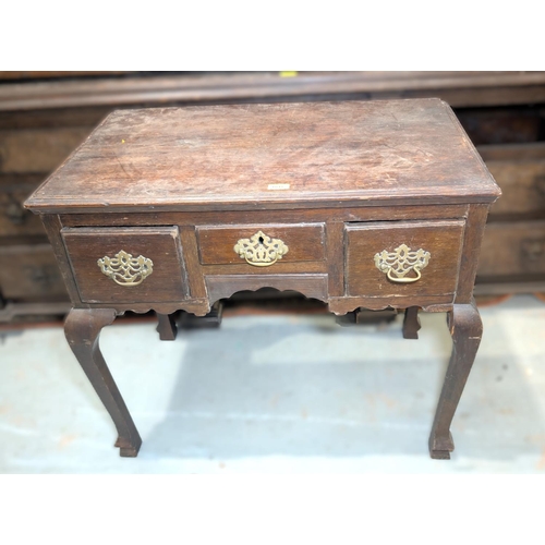 1007 - An 18th century country made oak low boy with 3 frieze drawers with brass swan neck handles on pierc... 