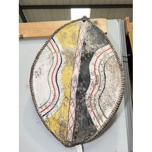 57 - A late 19th/early 20th century African (possibly Masai) hide shield with painted decoration to the f... 