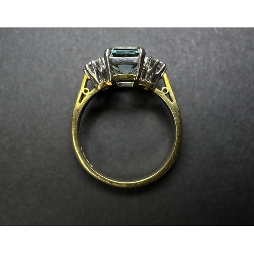 618 - An 18ct gold cushion cut aquamarine coloured stone flanked by two diamonds, approx. 4mm