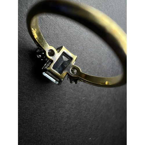 618 - An 18ct gold cushion cut aquamarine coloured stone flanked by two diamonds, approx. 4mm
