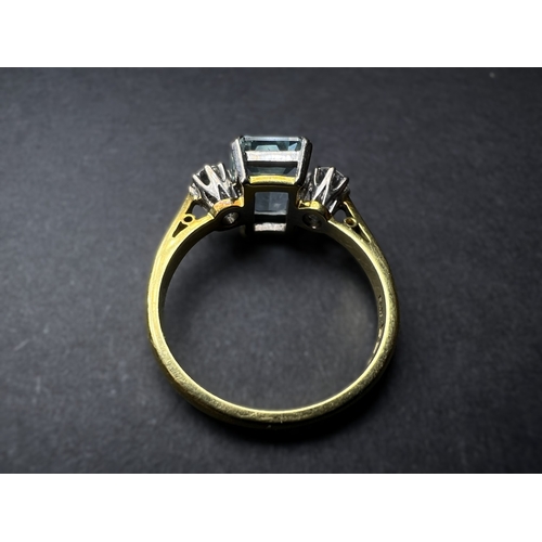 618 - An 18ct gold cushion cut aquamarine coloured stone flanked by two diamonds, approx. 4mm