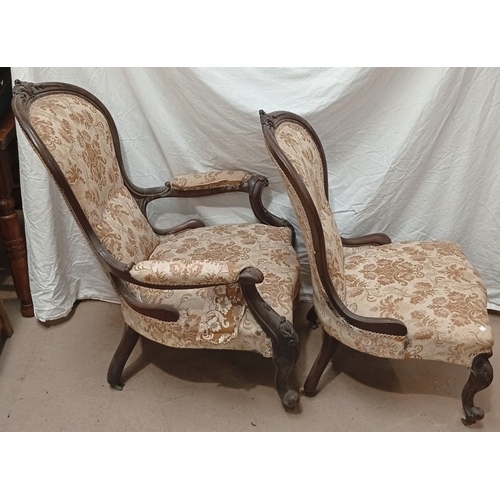 768 - A Victorian carved mahogany framed pair of Ladies and Gents armchairs upholstered in floral pattern.