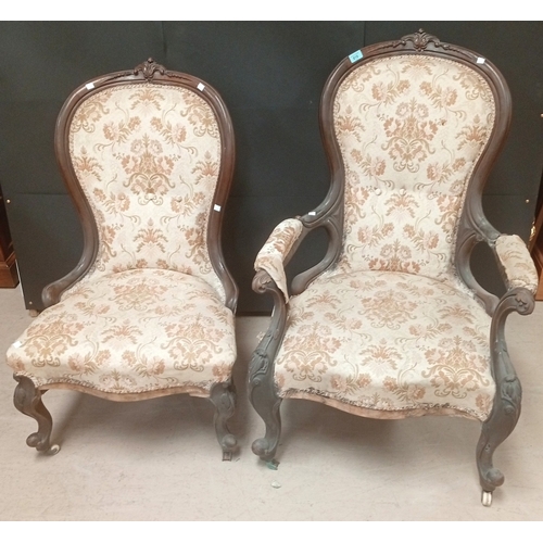 768 - A Victorian carved mahogany framed pair of Ladies and Gents armchairs upholstered in floral pattern.